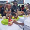 Friends eating banku and okro soup placed on a coffin during a funeral ceremony in Apam, Ghana