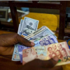 Ghana cedi banknotes with US dollar notes illustrating Ghana's latest foreign exchange market performance.