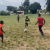 Blind students playing football at Bechem School for the Deaf and Blind during a match on a grass field in the Ahafo Region.