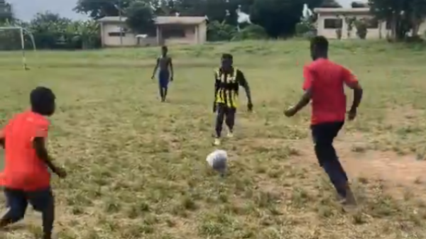 Blind students playing football at Bechem School for the Deaf and Blind during a match on a grass field in the Ahafo Region.
