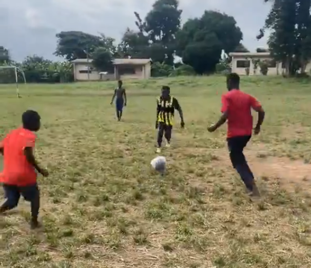 Blind students playing football at Bechem School for the Deaf and Blind during a match on a grass field in the Ahafo Region.