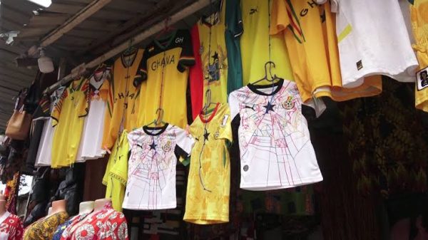 Unsold Black Stars jerseys and football merchandise displayed at a market stall after Ghana's World Cup exit